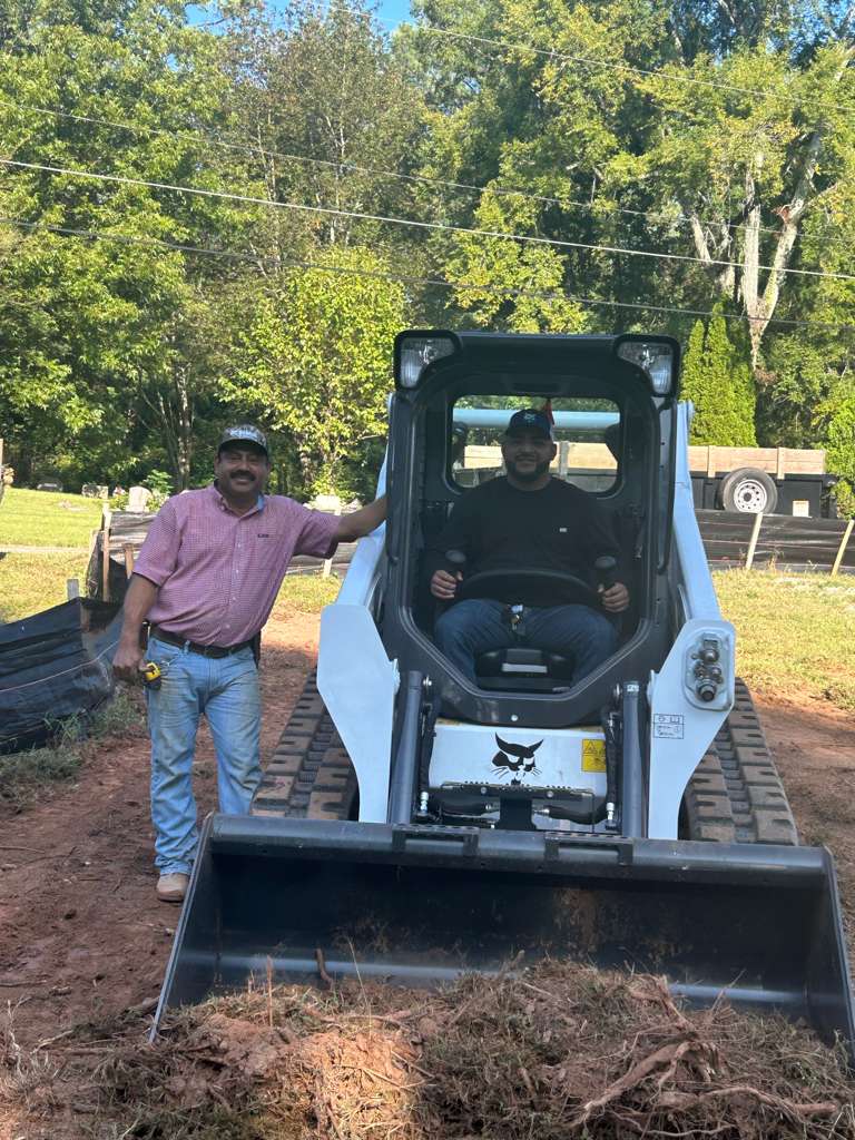 Filomeno and Adrian of Escobar Masonry with skid-steer loader on a job site