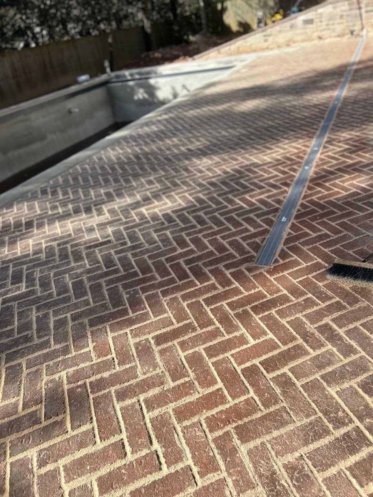 Brick pool deck with linear drain detail in North Atlanta, GA by Escobar Masonry & Hardscapes